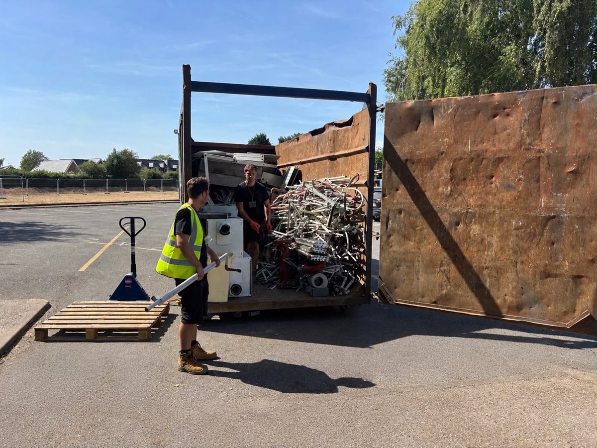 Scrap metal unloading beside a collection truck