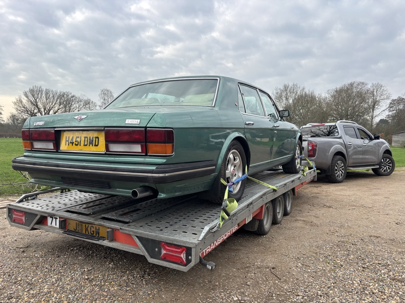 Classic green saloon secured on a transport trailer