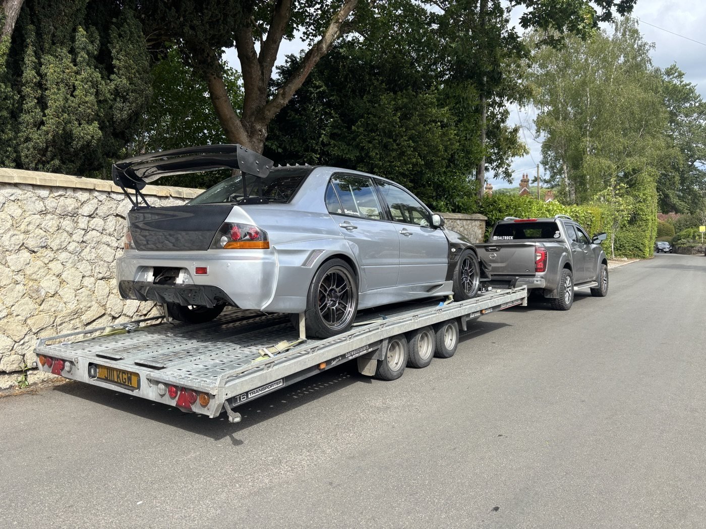 Silver performance car secured on a trailer