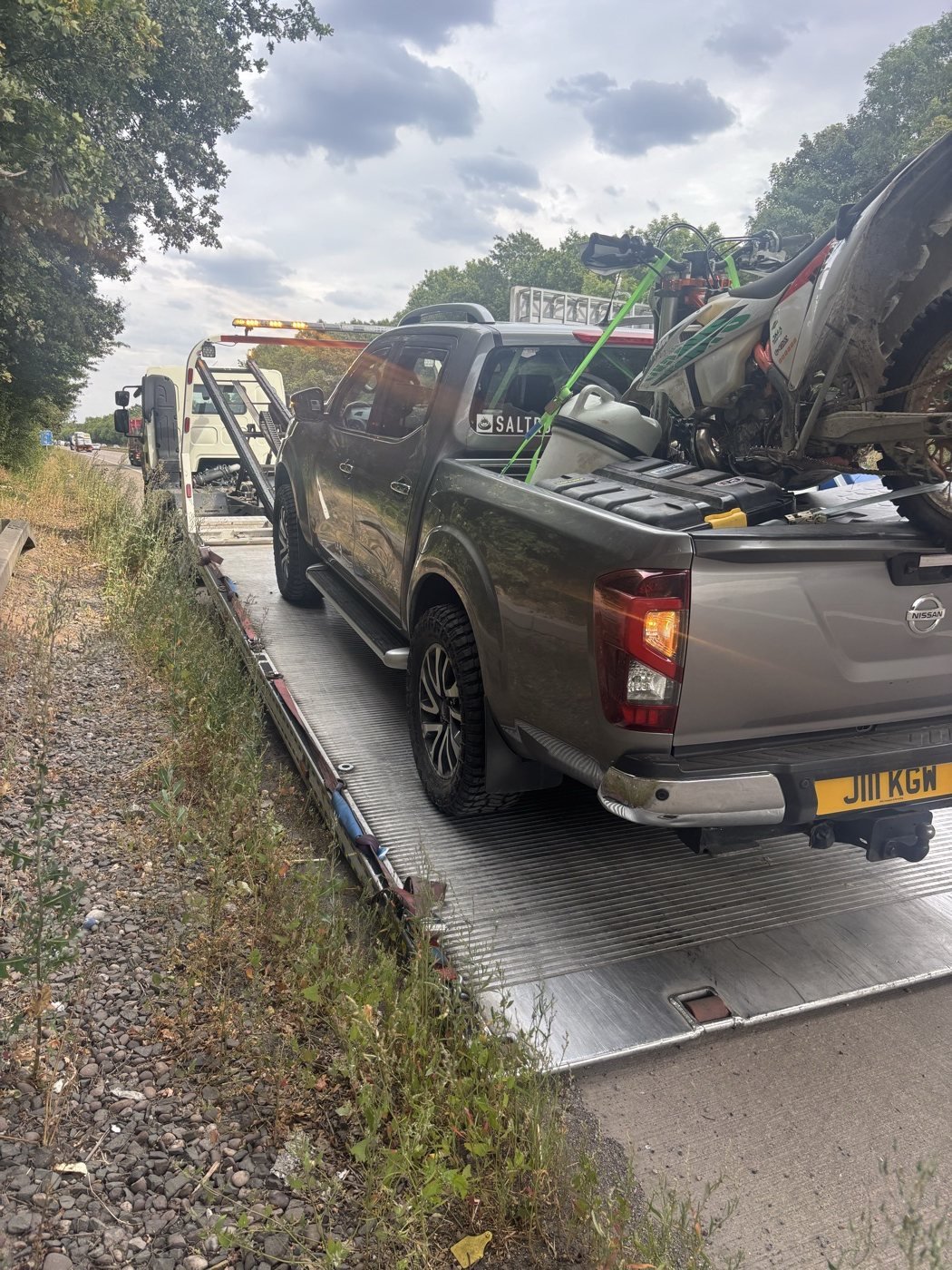 Pickup secured on a trailer beside a roadside