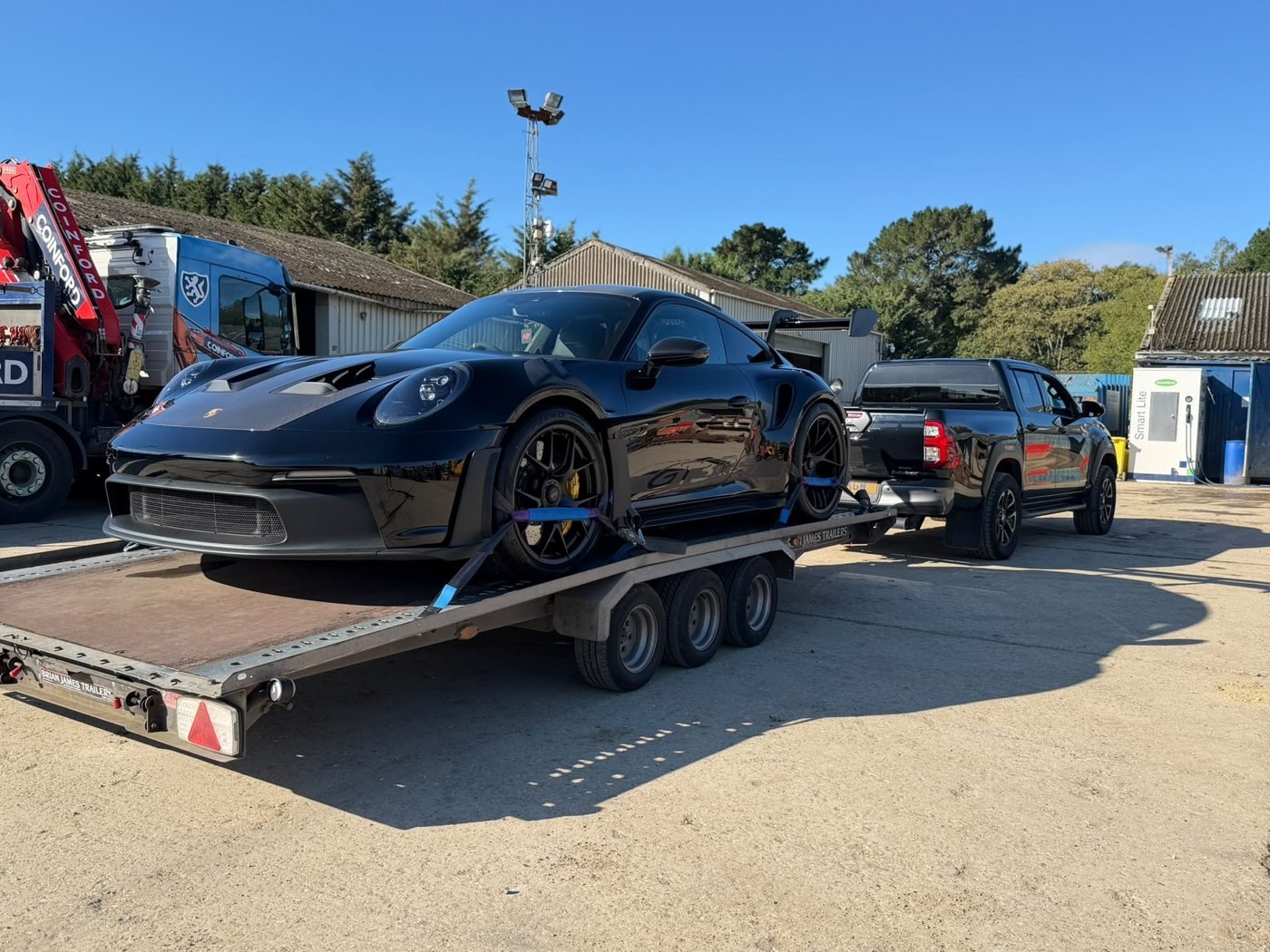 Black sports car secured on a transport trailer